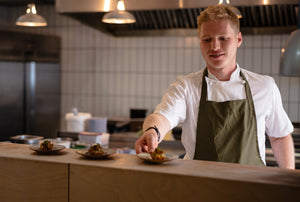 Chef in a kitchen setting with food on plates